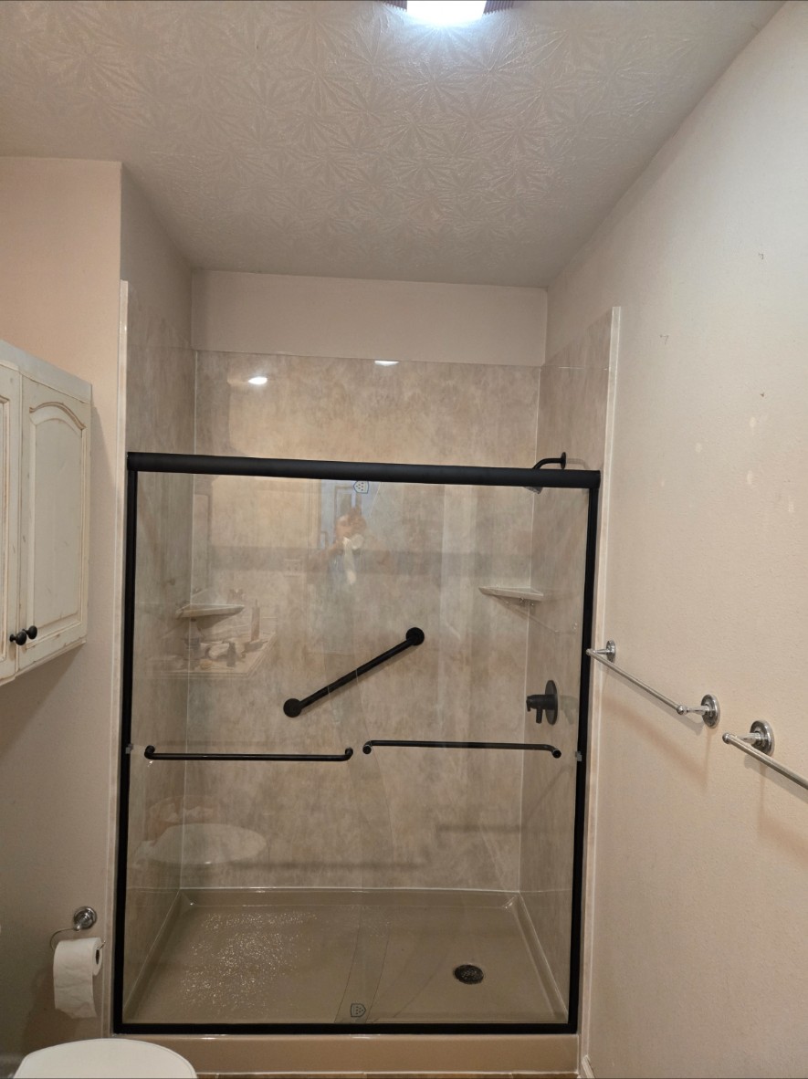 Finished shower with black-framed glass door