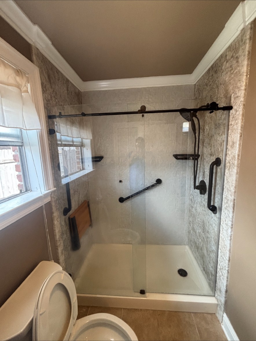 Finished walk-in shower with barn-door style glass