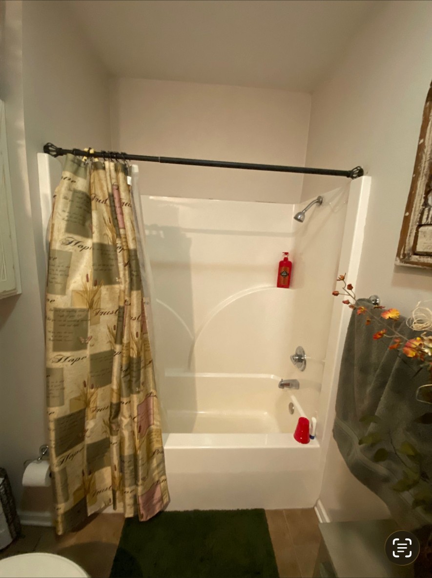 Plain builder-grade bathtub before the remodel